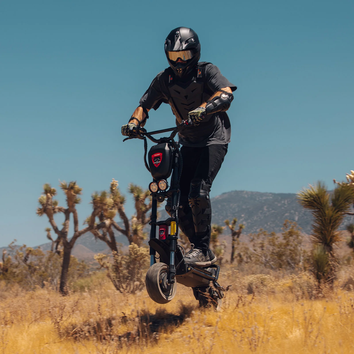 Rider using Kaabo Warrior 11 Pro Plus electric scooter to conquer steep off-road terrain with powerful dual motors