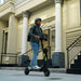 Person riding Kaabo Urban e-scooter through city streets